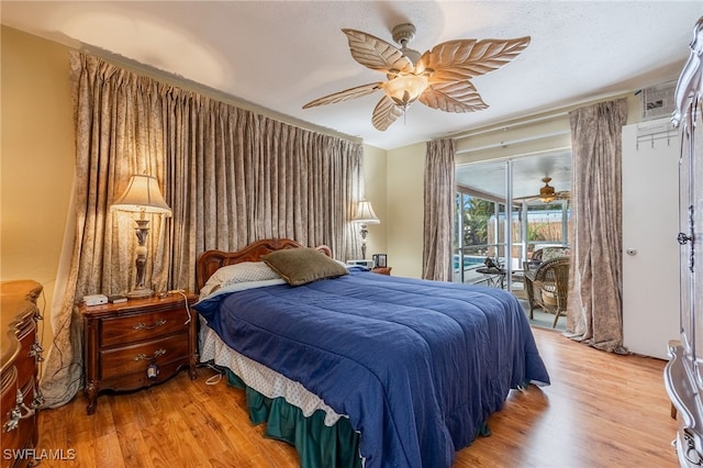 bedroom with access to outside, light wood-type flooring, and a ceiling fan