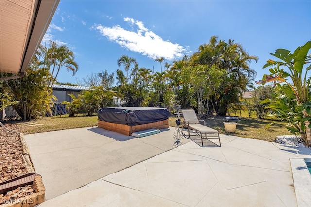 view of patio / terrace featuring fence and a hot tub