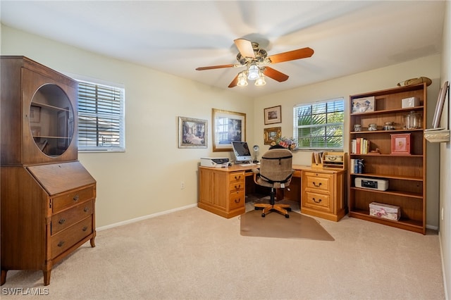 home office featuring light carpet, ceiling fan, and baseboards