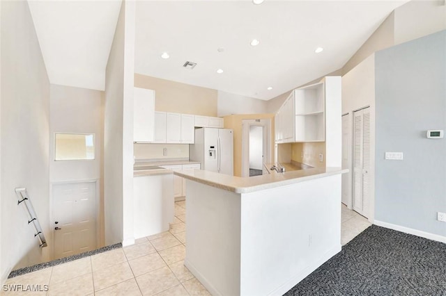 kitchen featuring light tile patterned floors, visible vents, light countertops, white fridge with ice dispenser, and open shelves