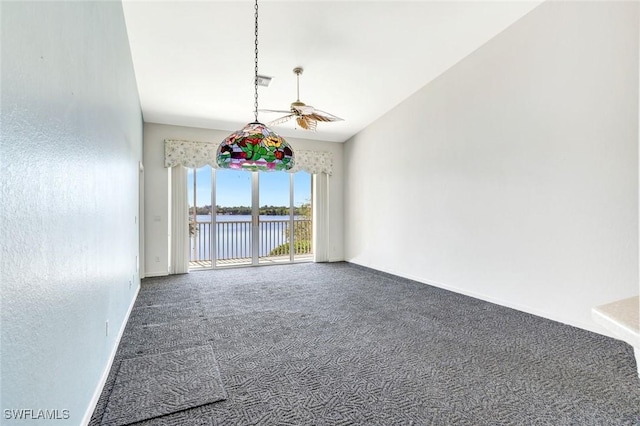 carpeted empty room with a water view, baseboards, and visible vents