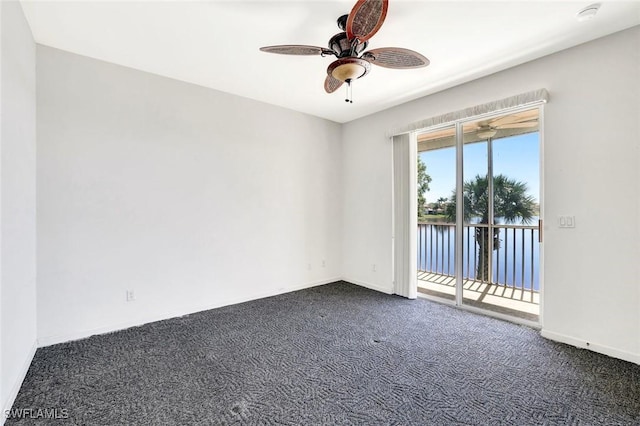 unfurnished room featuring baseboards, dark carpet, and a ceiling fan