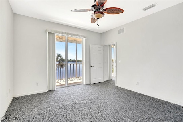 empty room with a ceiling fan, carpet, visible vents, and baseboards