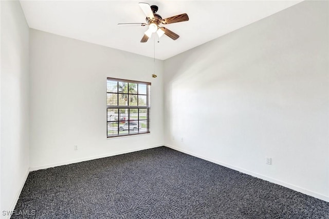 unfurnished room with ceiling fan, baseboards, and dark colored carpet