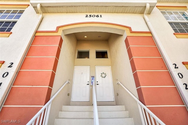 doorway to property featuring stucco siding