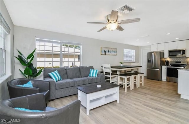 living room with light wood-style floors, recessed lighting, visible vents, and a ceiling fan