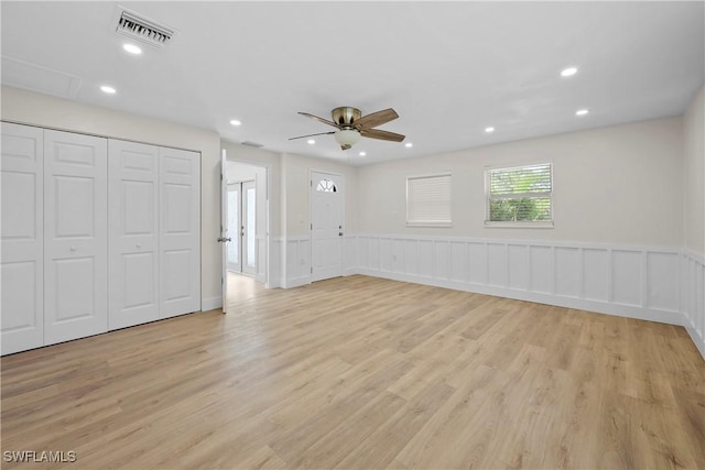 interior space featuring light wood-style flooring, recessed lighting, a wainscoted wall, a ceiling fan, and visible vents