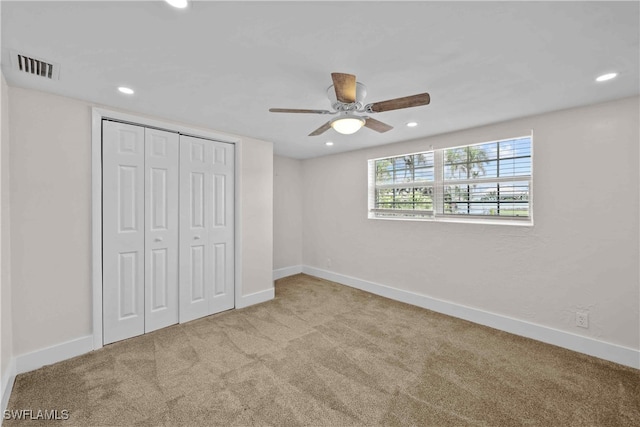 unfurnished bedroom featuring a closet, carpet, visible vents, and baseboards