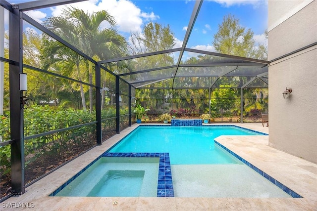 view of pool with a pool with connected hot tub, a patio area, and a lanai