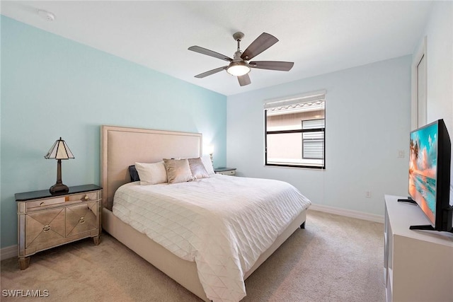 bedroom featuring light colored carpet, ceiling fan, and baseboards