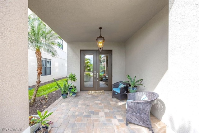 entrance to property featuring french doors and stucco siding