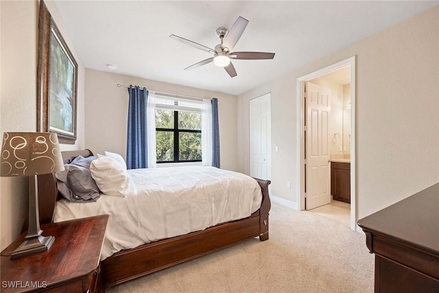 bedroom featuring baseboards, connected bathroom, a ceiling fan, and light colored carpet