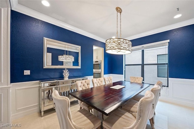 dining room with wainscoting, crown molding, a decorative wall, and light tile patterned flooring