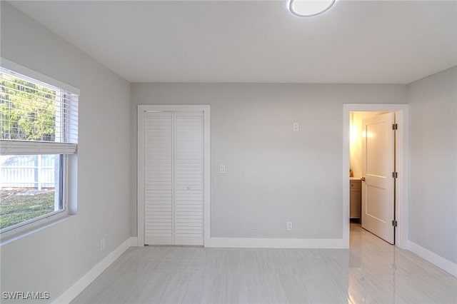 unfurnished bedroom with a closet and baseboards