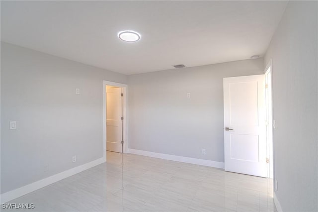 spare room with baseboards and visible vents