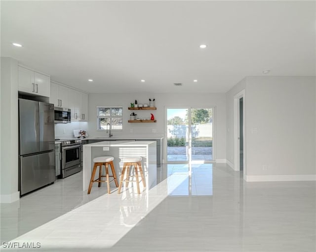 kitchen featuring recessed lighting, baseboards, white cabinets, appliances with stainless steel finishes, and open shelves