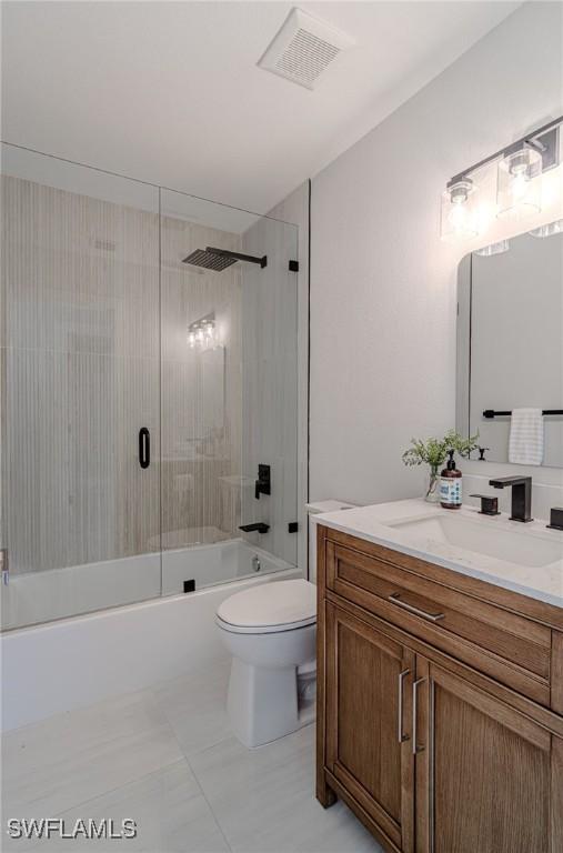 full bathroom with toilet, enclosed tub / shower combo, visible vents, and vanity