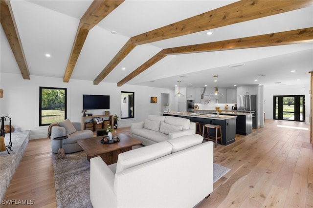 living room featuring recessed lighting, light wood-style floors, and vaulted ceiling with beams