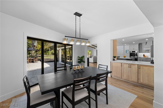 dining room featuring recessed lighting, baseboards, light wood finished floors, and a chandelier