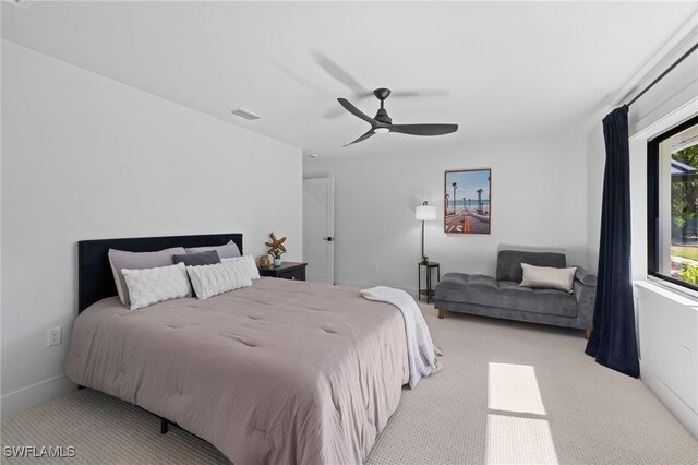 carpeted bedroom with visible vents, baseboards, and ceiling fan