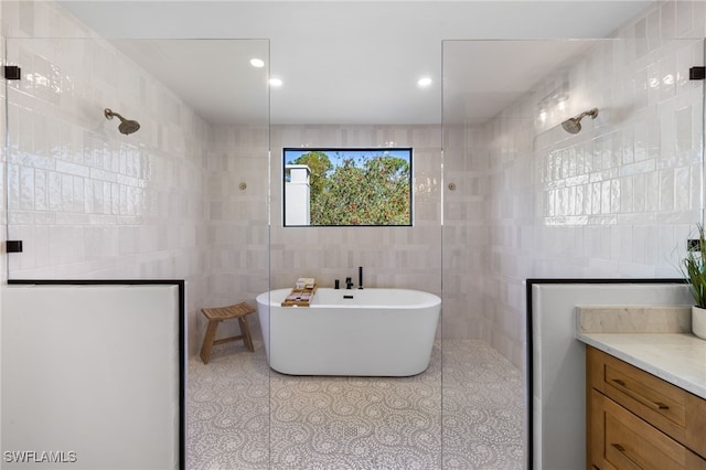 bathroom with tile patterned flooring, tile walls, a walk in shower, and a freestanding bath