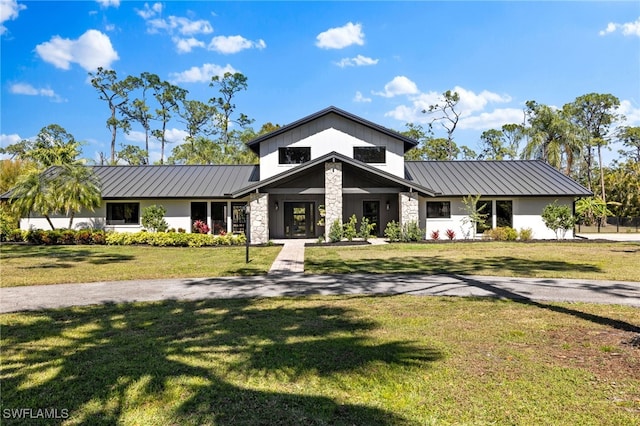 view of front of property featuring a standing seam roof, a front lawn, and metal roof