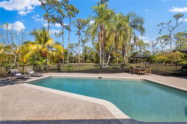 view of swimming pool featuring a patio area, fence, and a fenced in pool