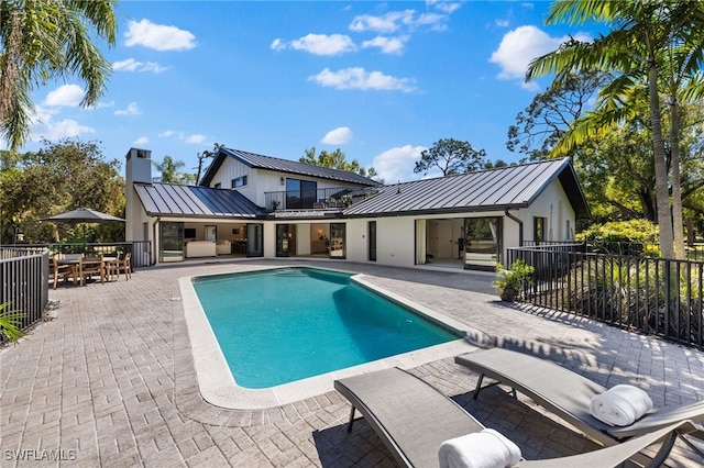 view of pool with a fenced in pool, fence, outdoor dining space, and a patio area