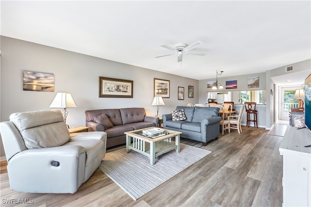 living area with ceiling fan, light wood-style flooring, and visible vents