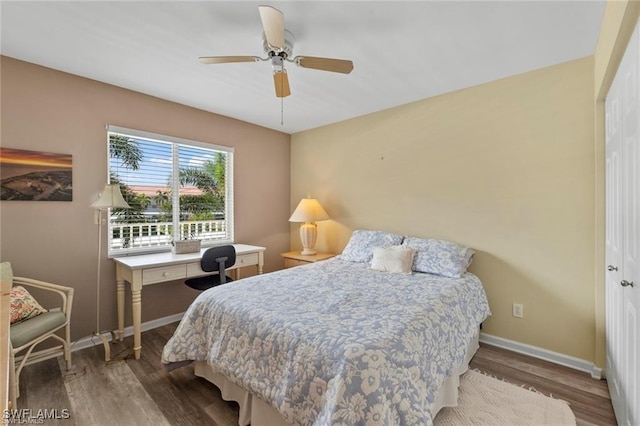 bedroom with ceiling fan, baseboards, and wood finished floors