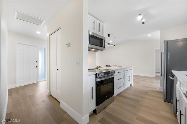 kitchen featuring stainless steel appliances, baseboards, white cabinets, light countertops, and light wood-type flooring