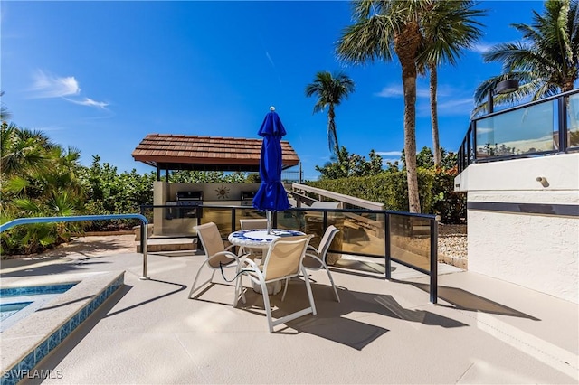 720 S Collier Blvd Unit 1007, Marco Island, FL 34145 - view of patio / terrace with exterior kitchen, a jacuzzi, and outdoor dining space