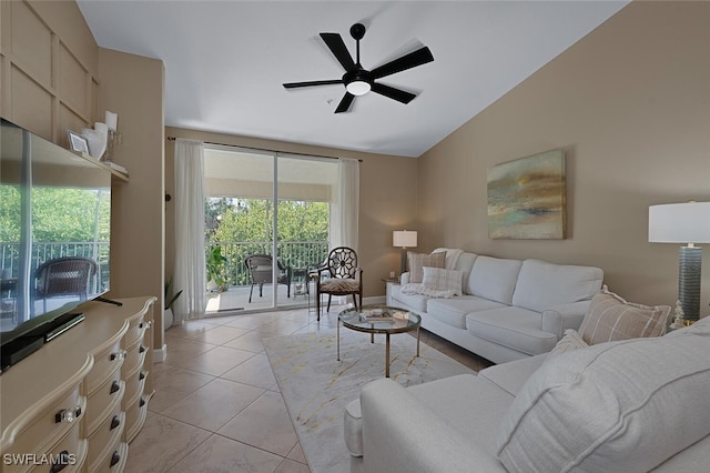 living area with light tile patterned floors, vaulted ceiling, and a ceiling fan