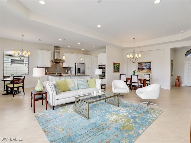 living room featuring a chandelier, a tray ceiling, light tile patterned floors, and recessed lighting