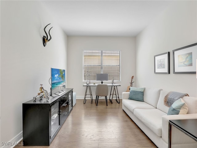 living area with baseboards and wood finished floors