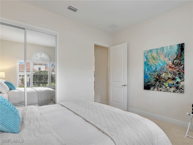 bedroom featuring a closet, carpet flooring, visible vents, and baseboards