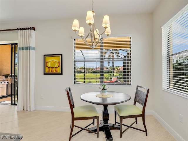 dining area featuring baseboards and a notable chandelier