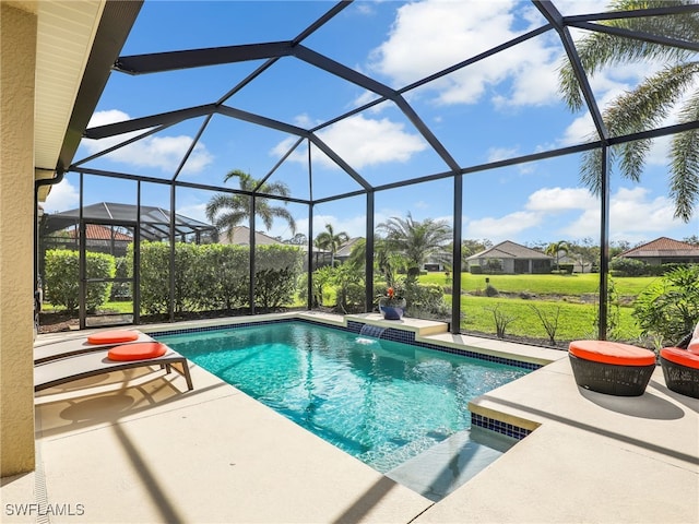 outdoor pool with glass enclosure, a patio area, and a yard