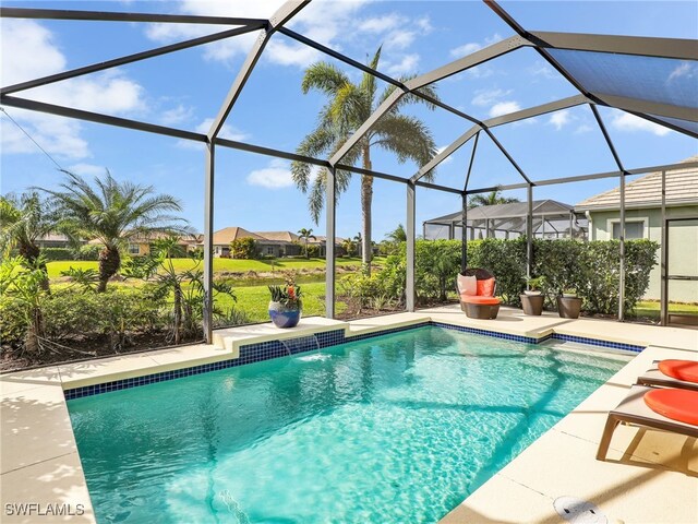 outdoor pool with glass enclosure and a patio