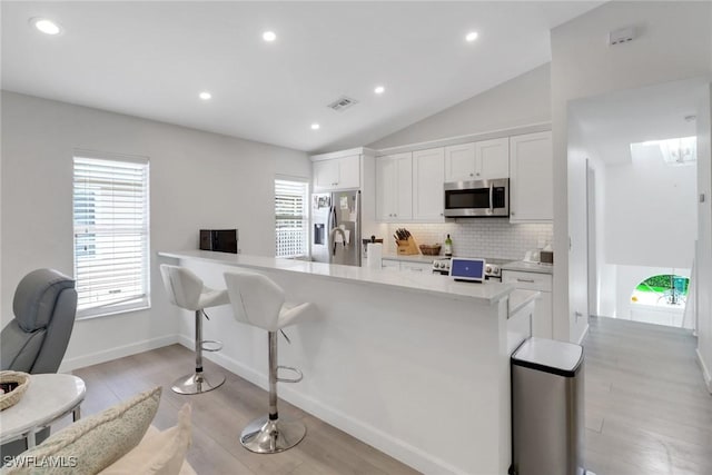 kitchen with visible vents, white cabinets, light countertops, appliances with stainless steel finishes, and decorative backsplash