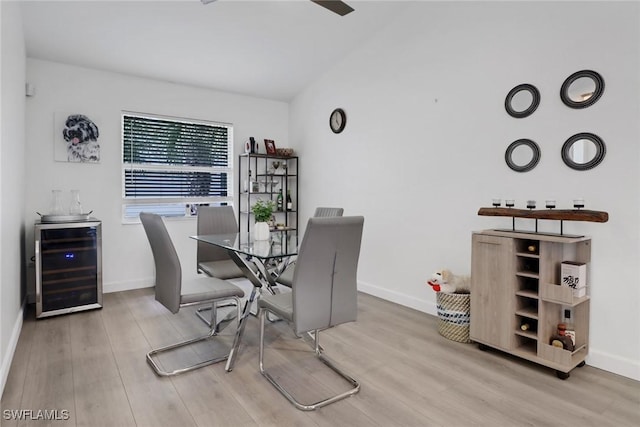 dining room featuring beverage cooler, baseboards, and wood finished floors