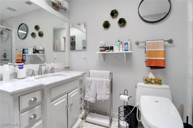 bathroom featuring visible vents, vanity, a tile shower, and toilet