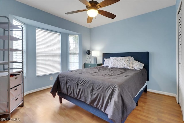 bedroom with ceiling fan, baseboards, and wood finished floors