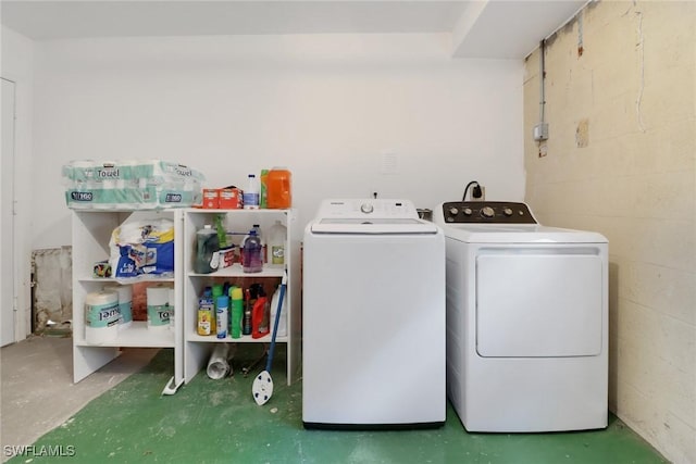 laundry area with concrete block wall, laundry area, and separate washer and dryer