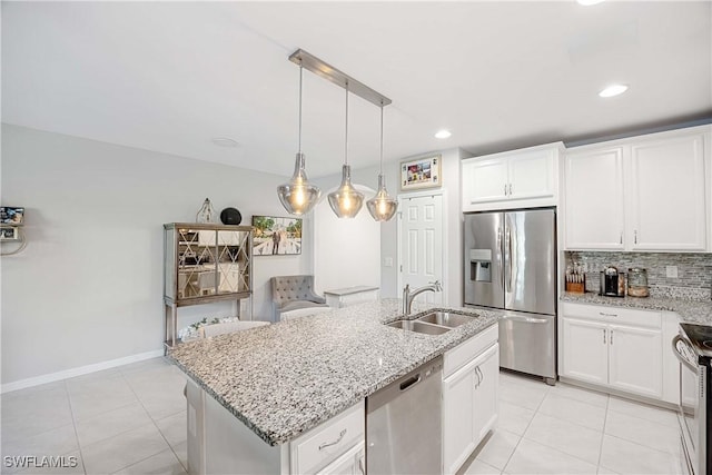 kitchen with light tile patterned flooring, a sink, white cabinets, appliances with stainless steel finishes, and backsplash