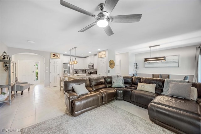 living room featuring light tile patterned flooring, recessed lighting, arched walkways, and ceiling fan