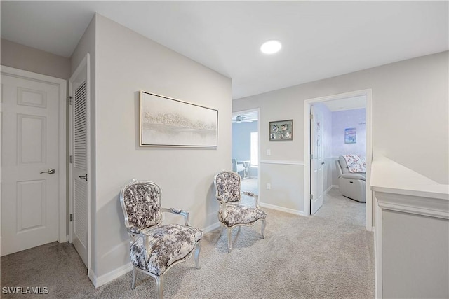 living area featuring baseboards and carpet floors