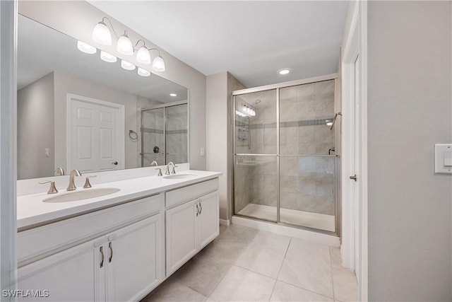 bathroom featuring a sink, double vanity, a stall shower, and tile patterned floors