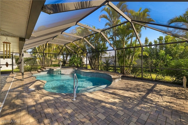 pool featuring glass enclosure and a patio area