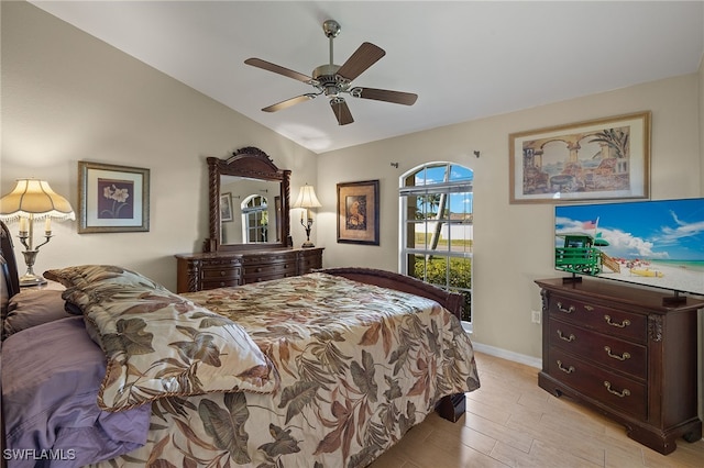 bedroom featuring baseboards, vaulted ceiling, light wood finished floors, and ceiling fan